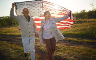 assisted living July holiday senior couple with American flag outside
