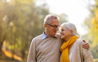 Happy senior couple walking together outside in fall