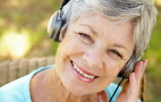 Happy senior woman smiling while listening to music with headphones on