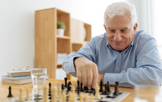 Senior man sitting at a table playing chess