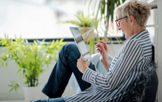A woman uses her tablet to stay connected to friends and family.