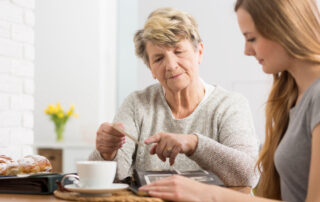 A senior woman showing her daughter a photo