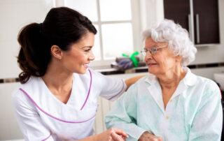 A senior woman and her caregiver smile together