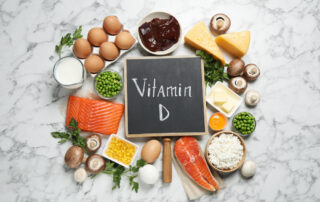 A chalkboard sign that reads 'Vitamin D' while surrounded by healthy foods