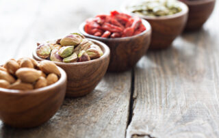 Variety of nuts and dried fruits in small wooden bowls
