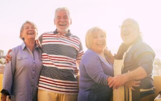 Four senior friends smiling and having a good time at the senior housing near me