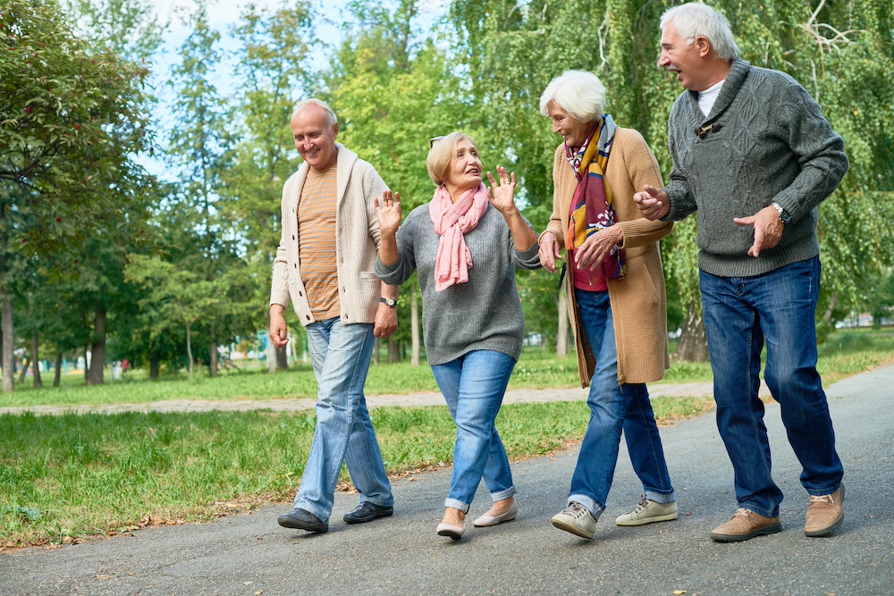 Four senior friends go on a walk at the senior housing near me