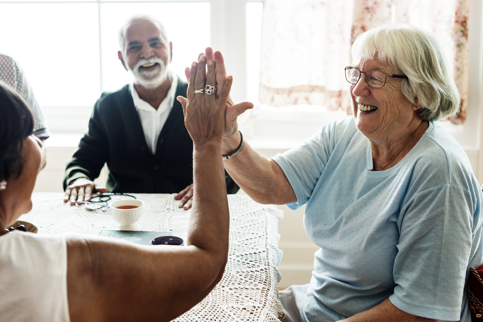 Seniors high five in memory care Macomb, MI.