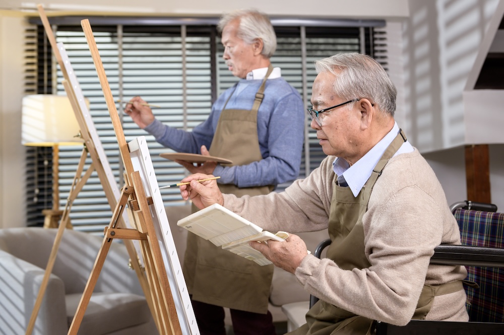 Senior men painting at their senior living communities